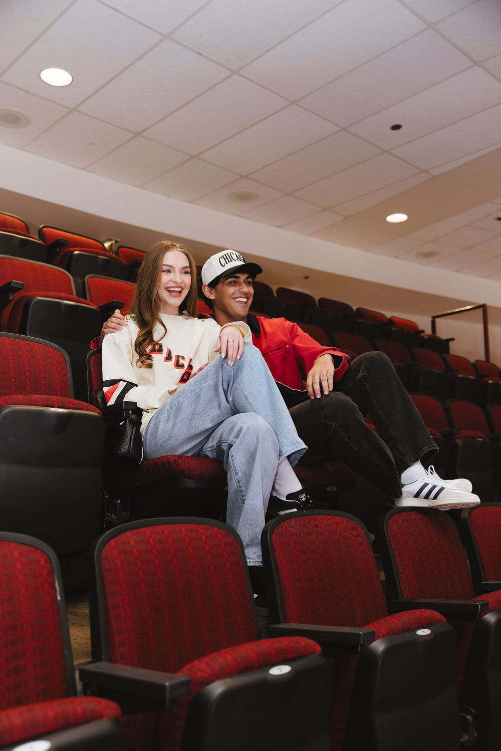 woman wearing cream Alice & Wonder long sleeve tee with diagonal Chicago wordmark graphic and Chicago Blackhawks secondary and primary logo on shoulders with jersey stripes on sleeves