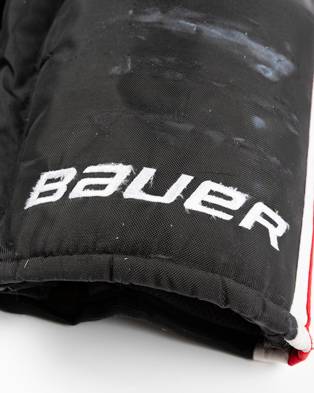 black Bauer hockey pants used by Chicago Blackhawks player Alex Vlasic - Bauer detail lay flat