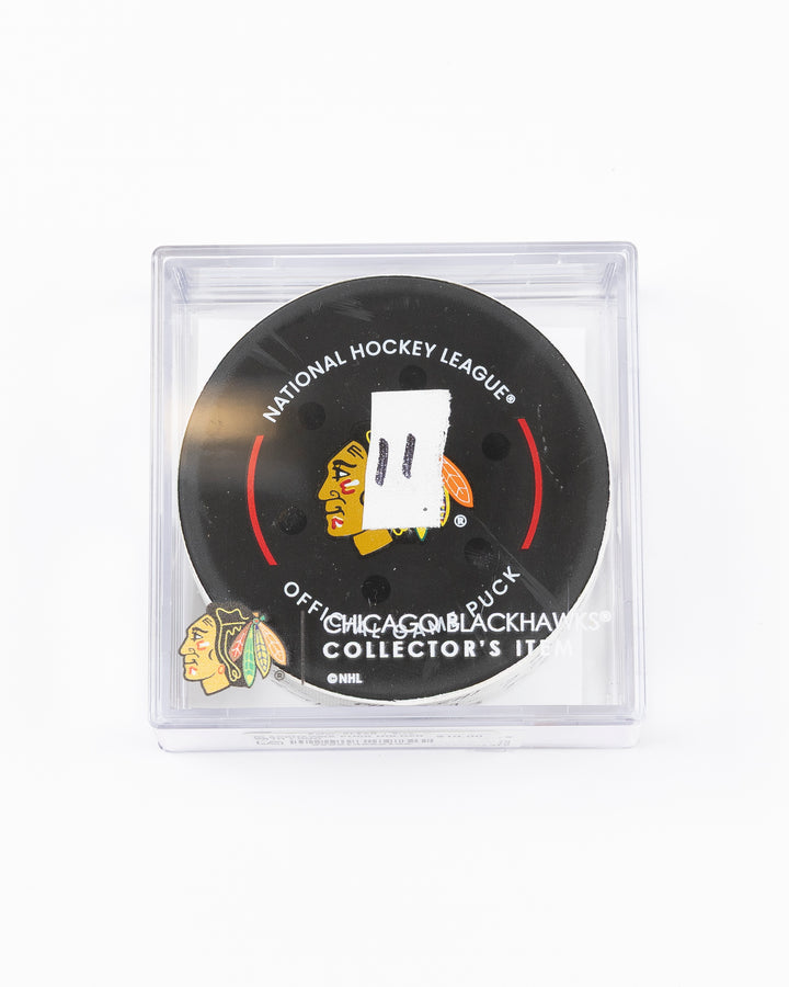 official game used hockey goal puck used by Chicago Blackhawks player Lukas Reichel - front lay flat in case