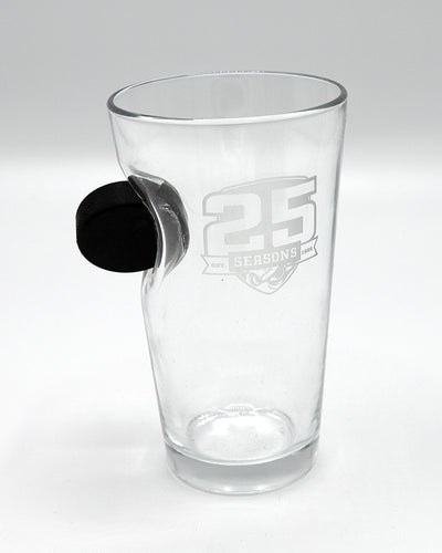 25th anniversary Rockford IceHogs pint glass with puck going through the glass - front lay flat