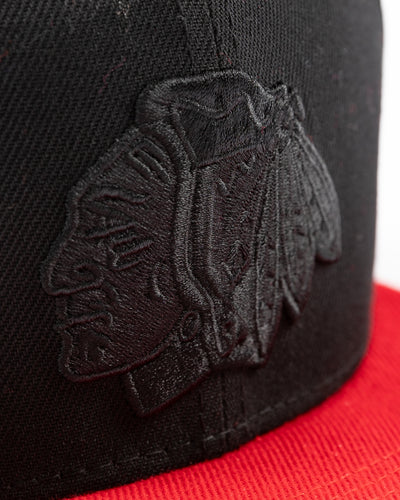 two tone black and red youth snapback cap with Chicago Blackhawks tonal primary logo on front and red wordmark on back - detail lay flat