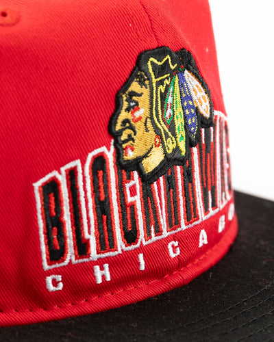 two tone red and black youth snapback cap with Chicago Blackhawks wordmark and primary logo across front - detail lay flat