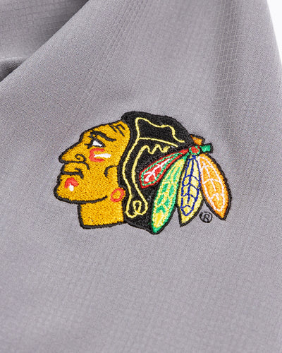 grey TravisMathew full zip jacket with Chicago Blackhawks primary logo embroidered on left shoulder - detail lay flat