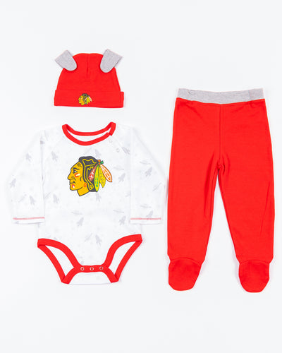 newborn set with onesie, beanie and pants with Chicago Blackhawks primary logo on all over rocket print - front lay flat