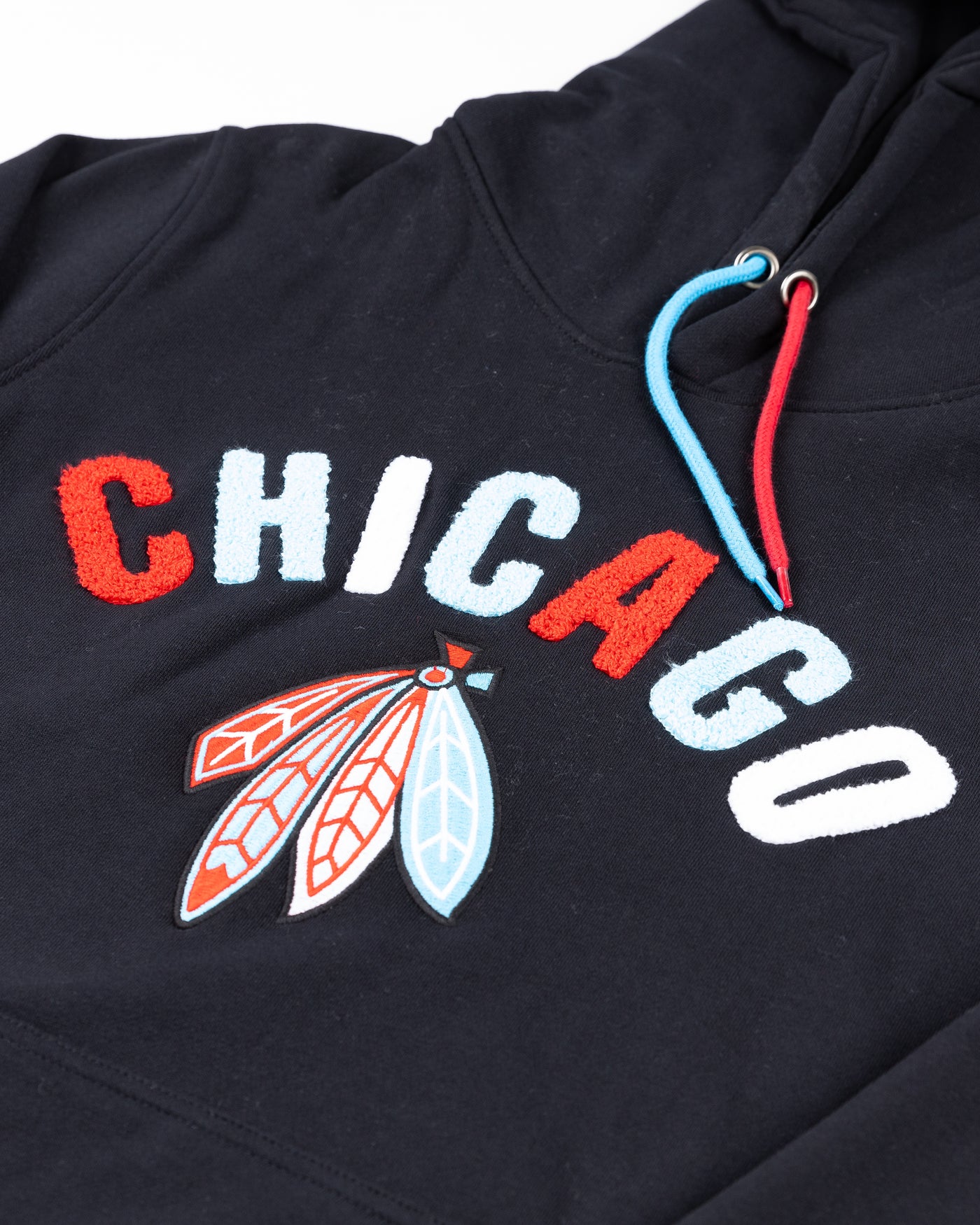black hoodie with Chicago wordmark and Chicago Blackhawks four feathers logo embroidered across the front - detail lay flat