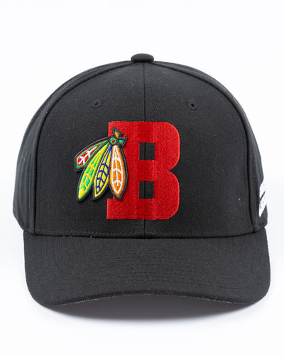black Mitchell & Ness snapback with Chicago Blackhawks four feathers logo embroidered on red letter B - front lay flat
