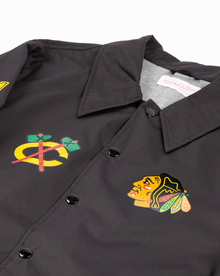 black Mitchell & Ness coaches jacket with Chicago Blackhawks secondary logo on right chest and primary logo on left chest and wordmark down right sleeve - front detail lay flat