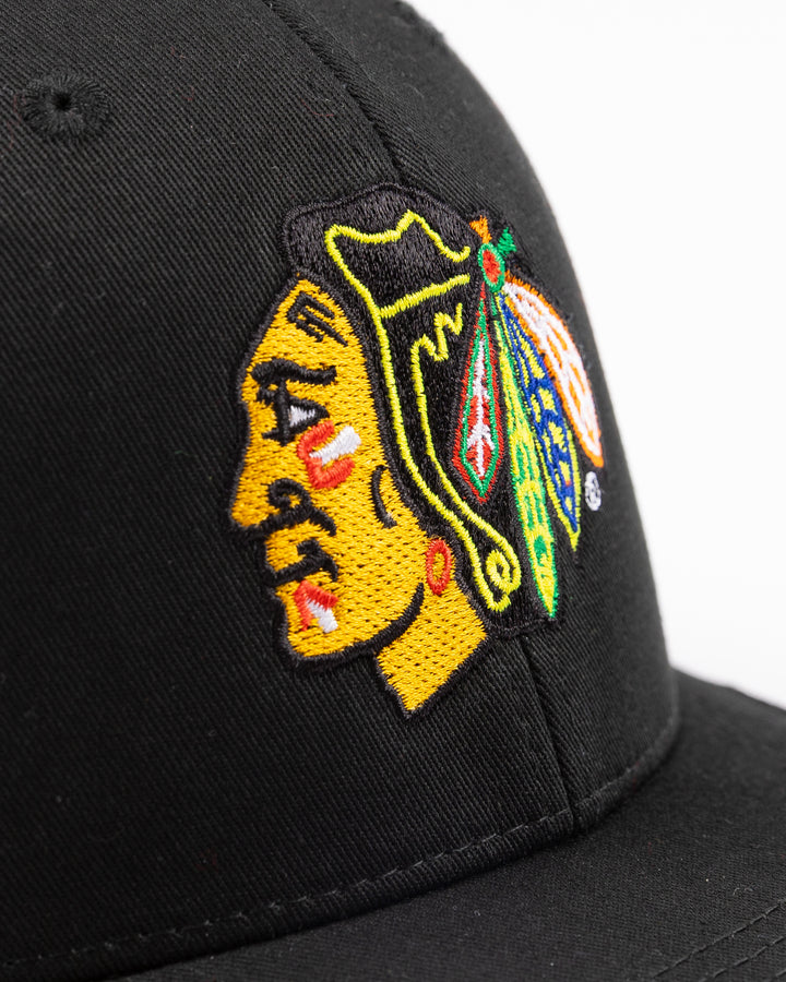 black Bauer adjustable mesh snapback trucker hat with Chicago Blackhawks primary logo embroidered on front - front detail lay flat