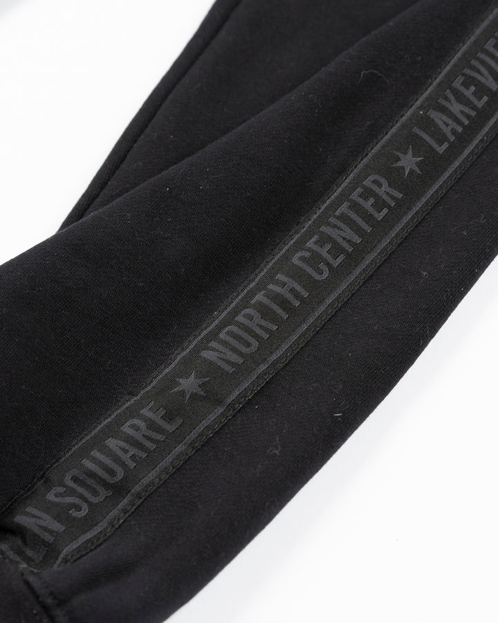 black sweatpants with Chicago Blackhawks secondary logo embroidered in Chicago flag colorway on left thigh and Chicago neighborhood names down sides - alt detail lay flat
