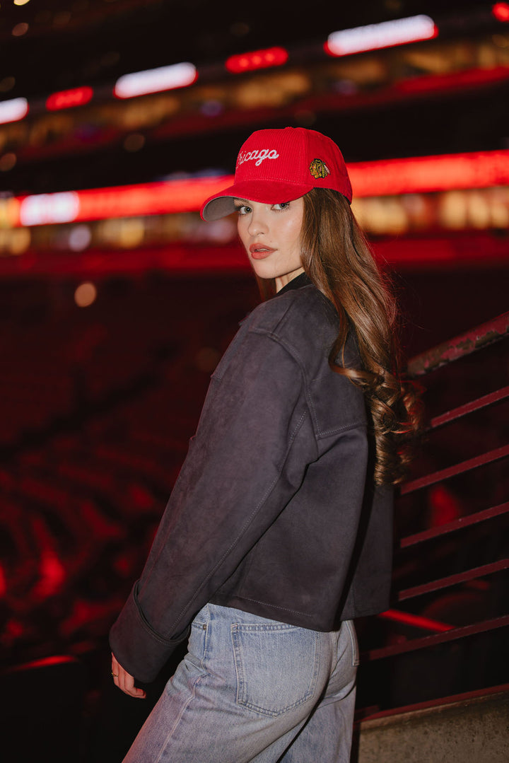 woman wearing red corduroy Alice & Wonder adjustable hat with white chainstitched Chicago script graphic on front and Chicago Blackhawks primary logo on left side