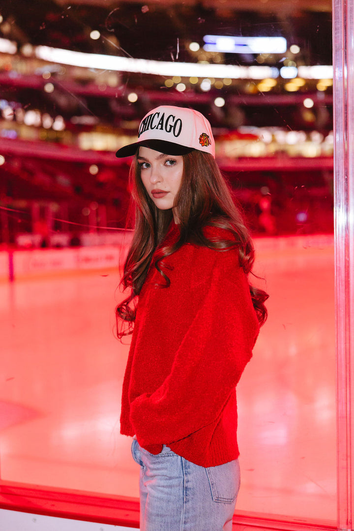 woman earing cream and black Alice & Wonder hat with Chicago wordmark on front and Chicago Blackhawks primary logo on left side