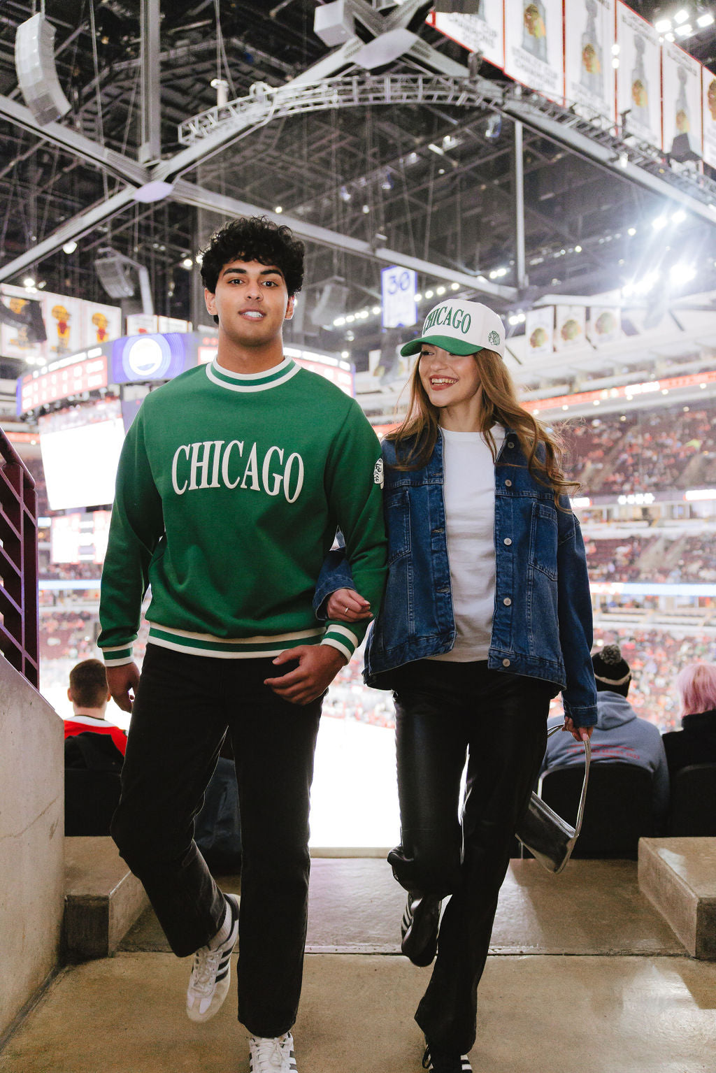 man wearing green Alice & Wonder crewneck sweater with Chicago wordmark graphic and tonal Chicago Blackhawks primary logo on left shoulder