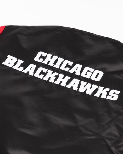 black Mitchell & Ness satin varsity jacket with Chicago Blackhawks primary logo on left chest and wordmark on back yoke - detail back lay flat