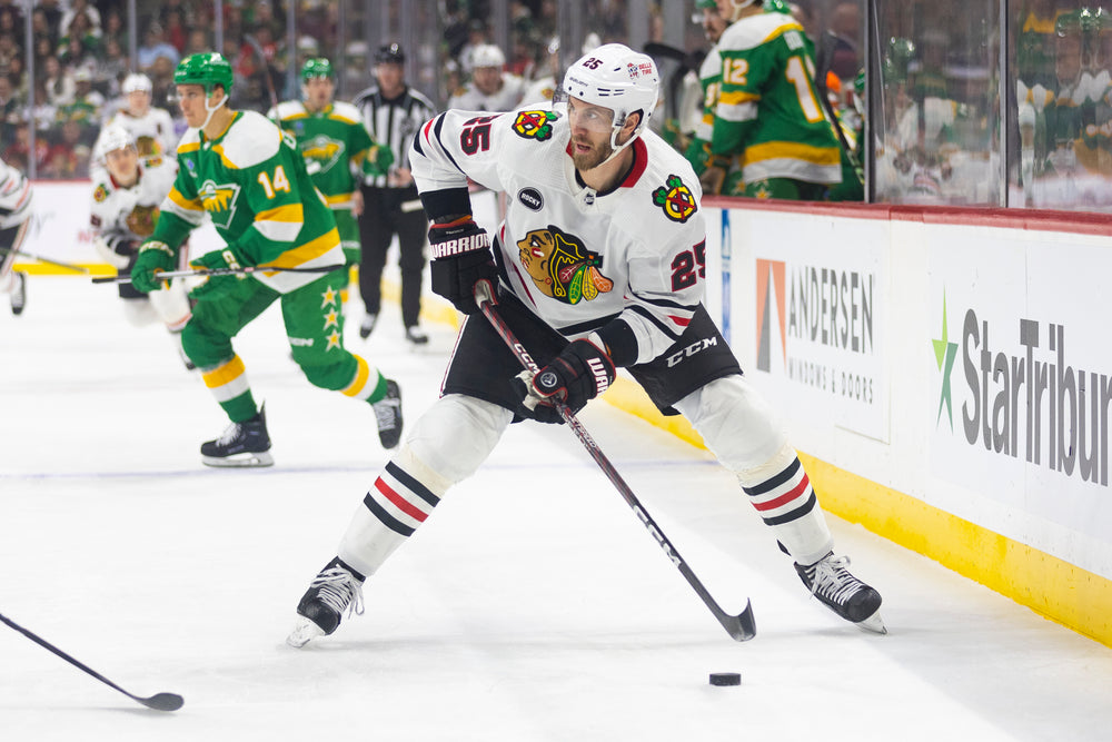 Jarred Tinordi in white Chicago Blackhawks away uniform at Minnesota