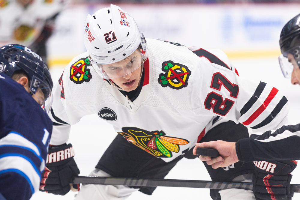 Lukas Reichel in white away Chicago Blackhawks uniform at Winnipeg