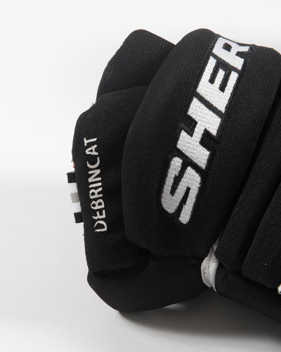 Autographed Chicago Blackhawks Sherwood Alex DeBrincat hockey gloves - close up of player label
