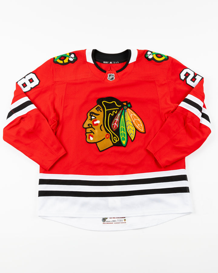 red Chicago Blackhawks home jersey with Vinnie Hinostroza name and number - front lay flat