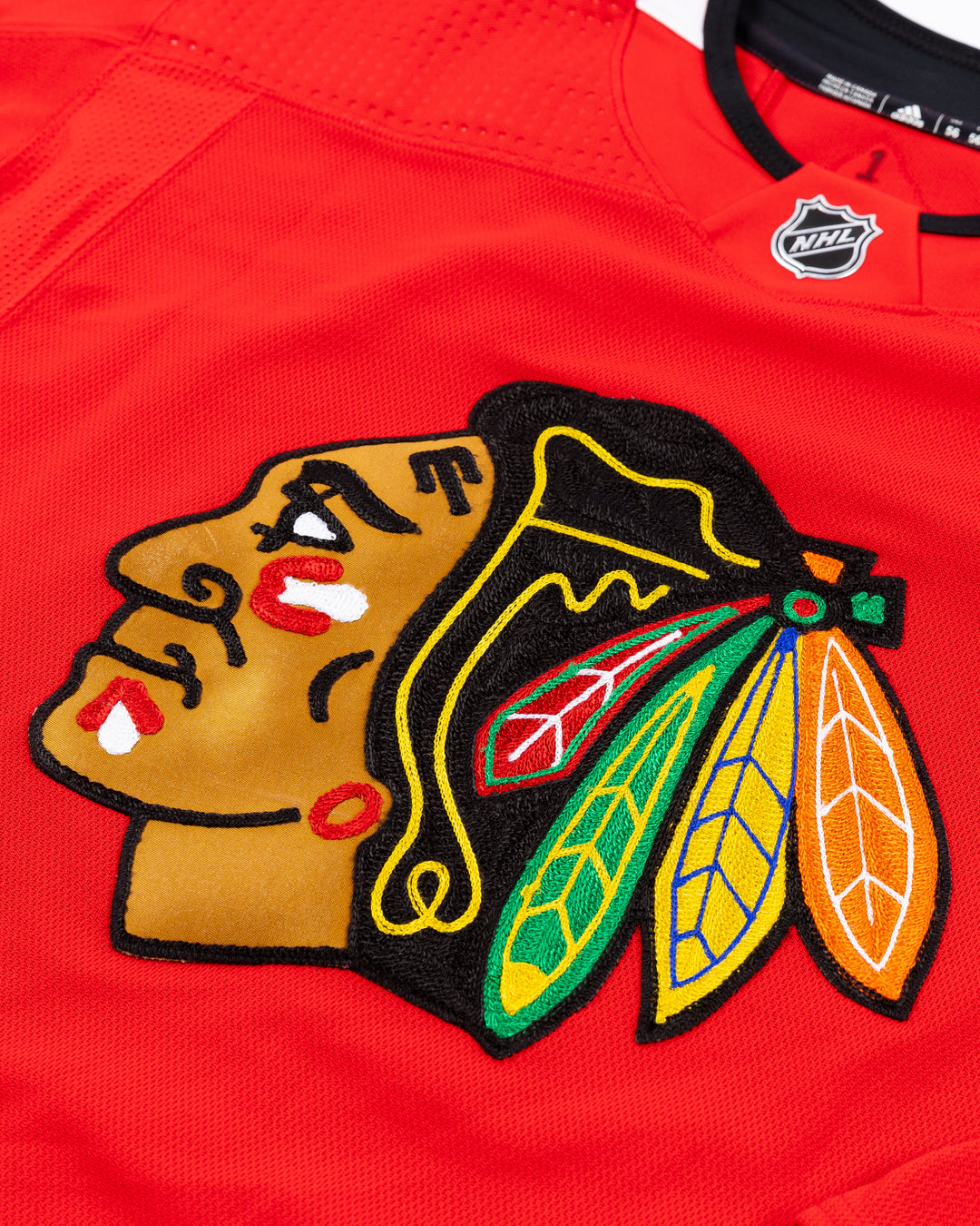 red Chicago Blackhawks home jersey with Vinnie Hinostroza name and number - front detail lay flat