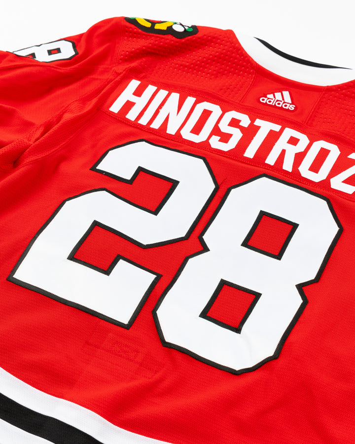 red Chicago Blackhawks home jersey with Vinnie Hinostroza name and number - back detail lay flat