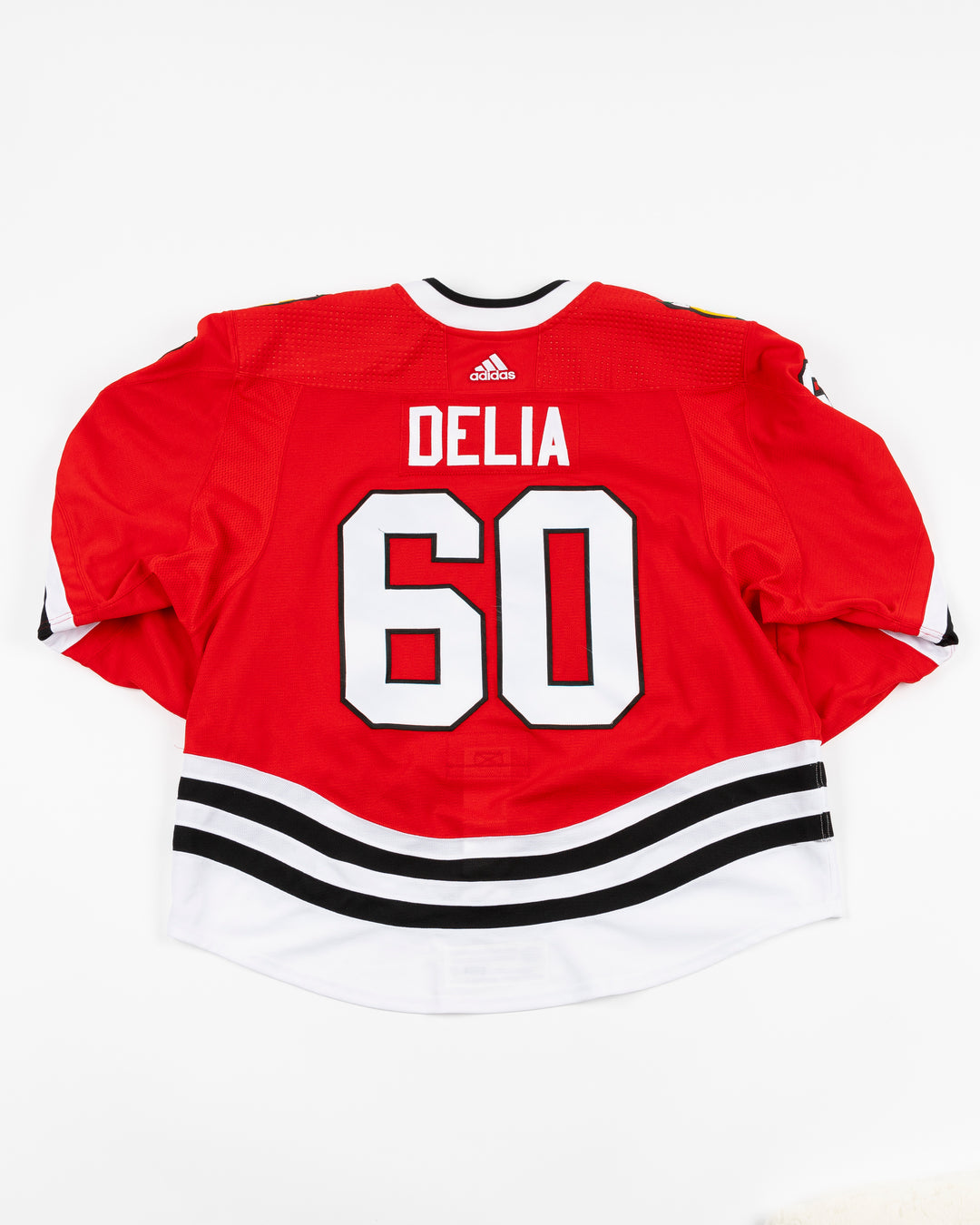 red home game-used Chicago Blackhawks jersey of Collin Delia - back lay flat