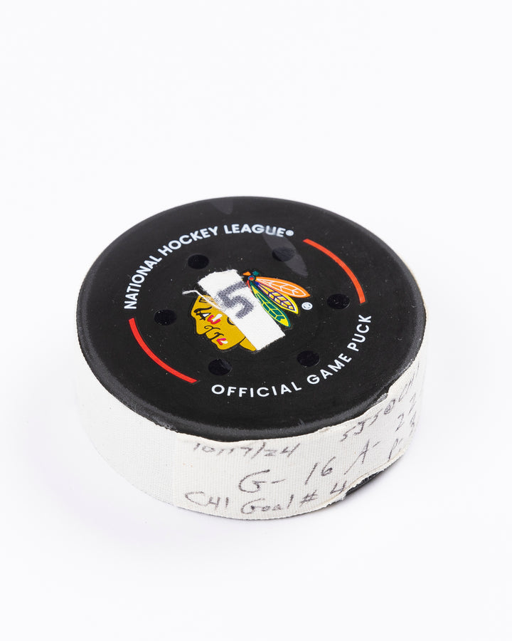 game-used hockey goal puck scored by Chicago Blackhawks player Jason Dickinson - front angled lay flat