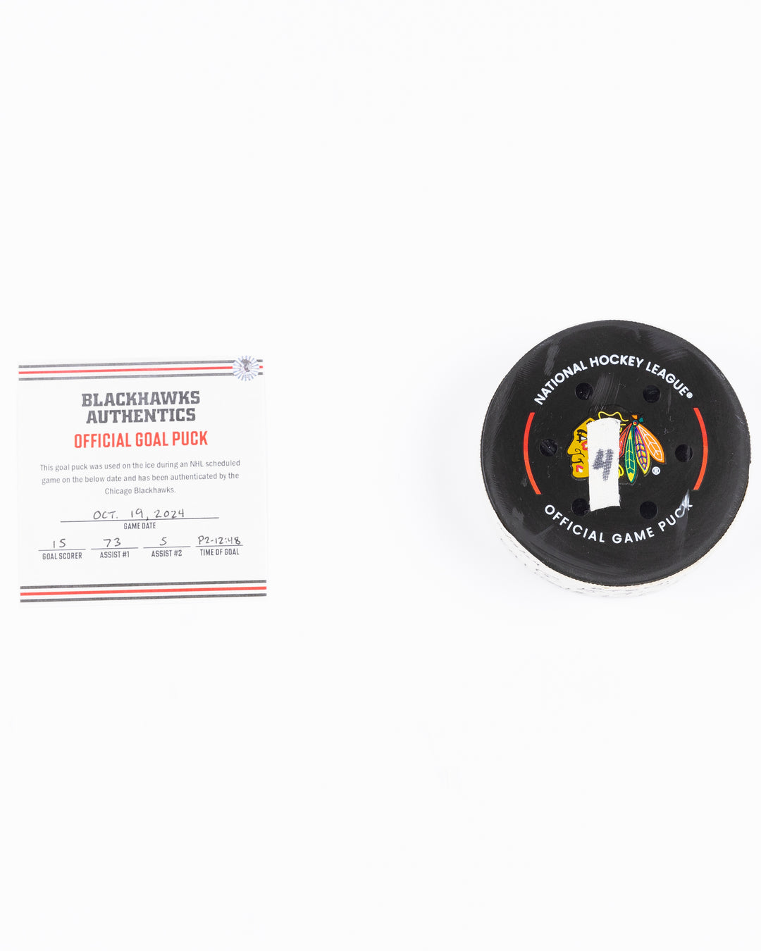 game used hockey goal puck scored by Chicago Blackhawks player Craig Smith on game on October 19, 2024 - front lay flat with certificate