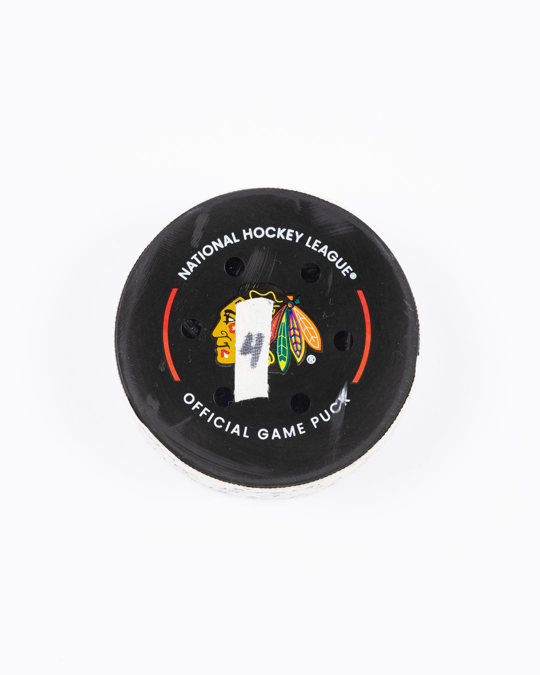 game used hockey goal puck scored by Chicago Blackhawks player Craig Smith on game on October 19, 2024 - front lay flat