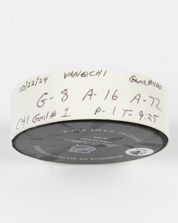 game used hockey goal puck scored by Chicago Blackhawks player Ryan Donato during game on October 22, 2024 - side lay flat