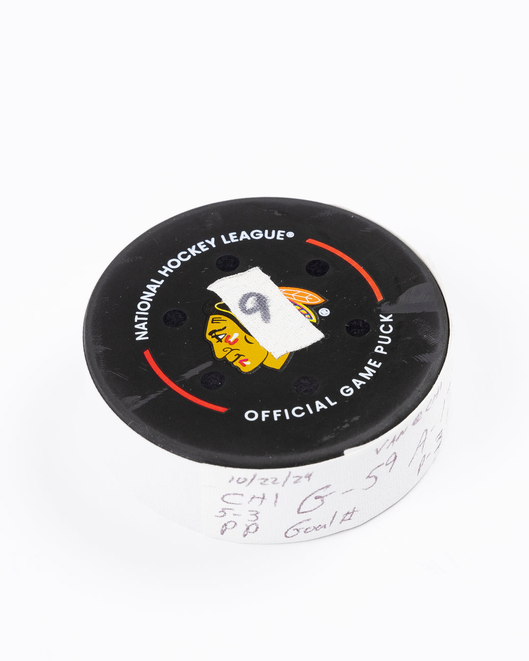 game used hockey goal puck scored by Chicago Blackhawks player Tyler Bertuzzi during game on October 22, 2024 - front angled lay flat