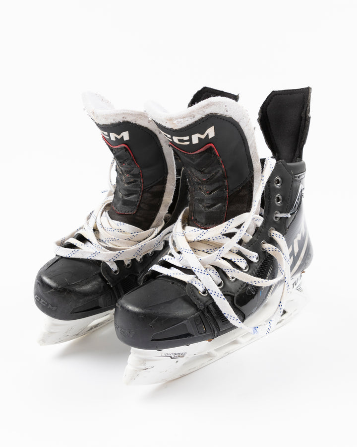 black CCM hockey skates worn and used by Chicago Blackhawks player Jason Dickinson - front lay flat