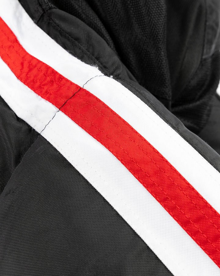 black Bauer hockey pants used by unspecified Chicago Blackhawks player - stripe detail lay flat