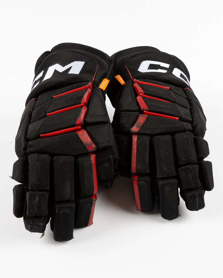 black CCM hockey gloves used by Chicago Blackhawks player Jason Dickinson - front lay flat