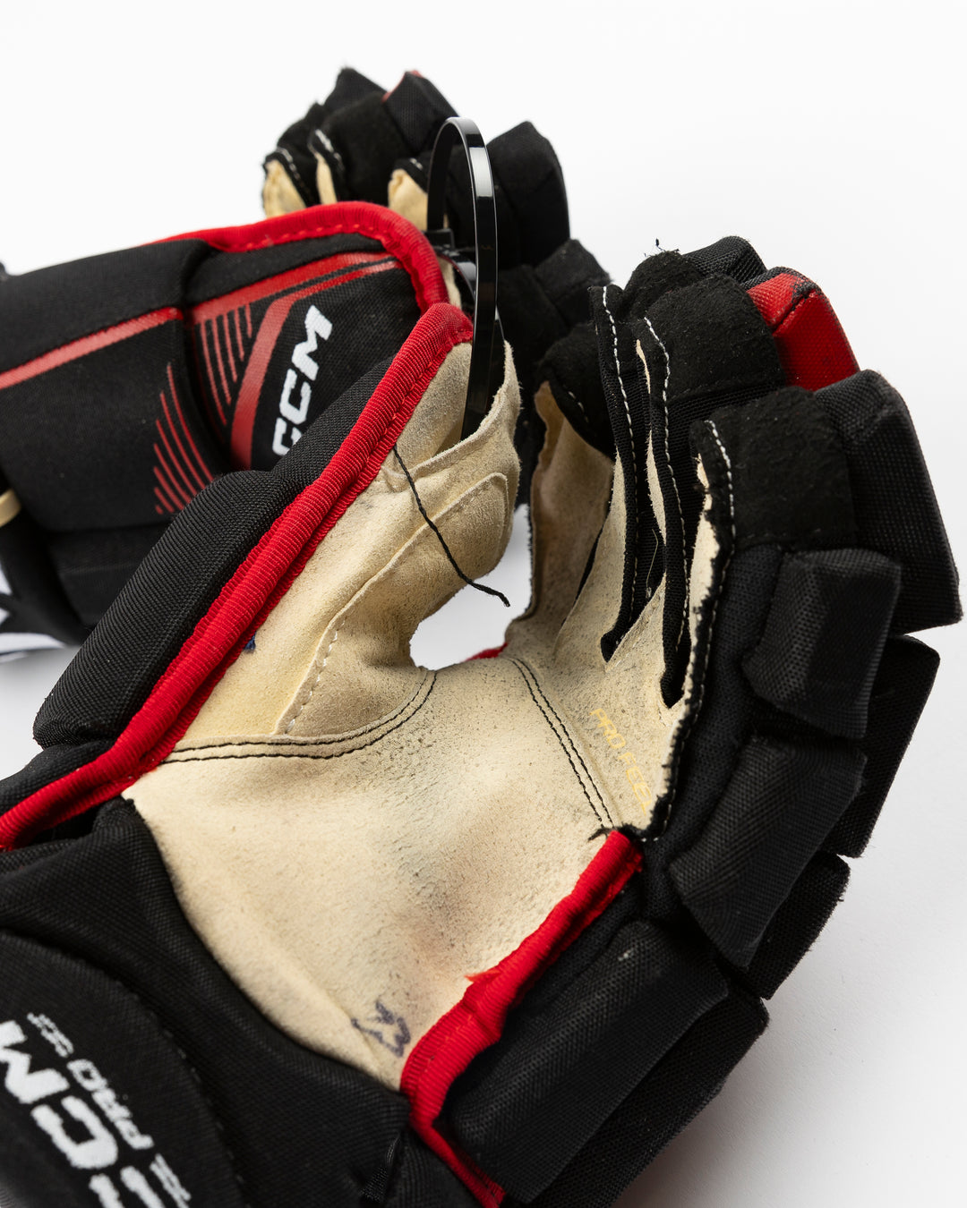 black CCM hockey gloves used by Chicago Blackhawks player Philipp Kurashev - front palm up lay flat