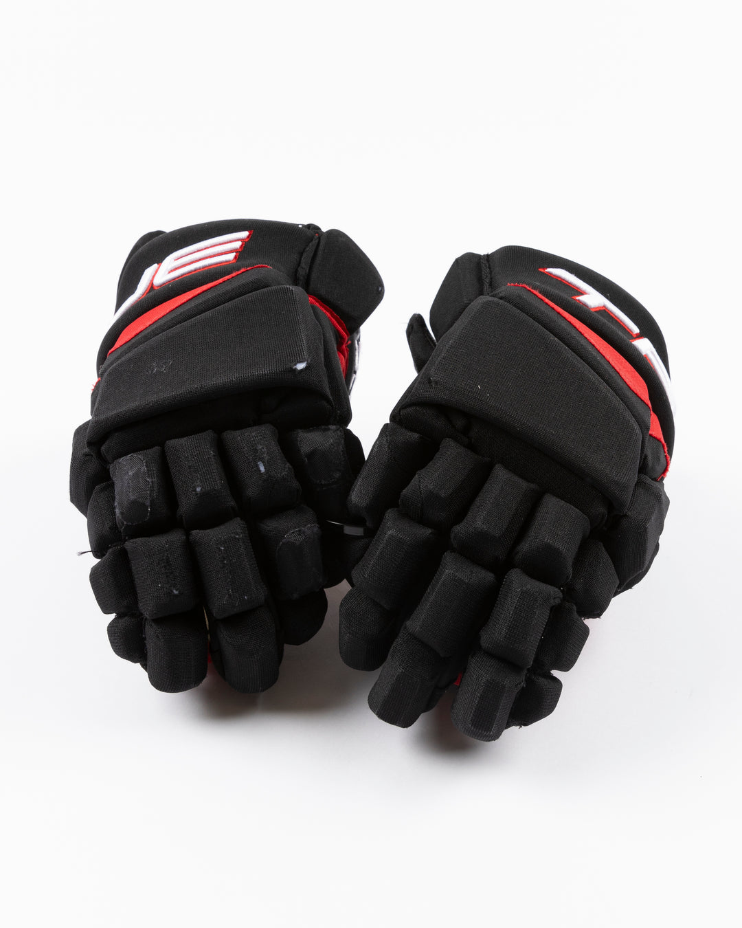 black TRUE brand hockey gloves used by Chicago Blackhawks player Tyler Bertuzzi - front lay flat