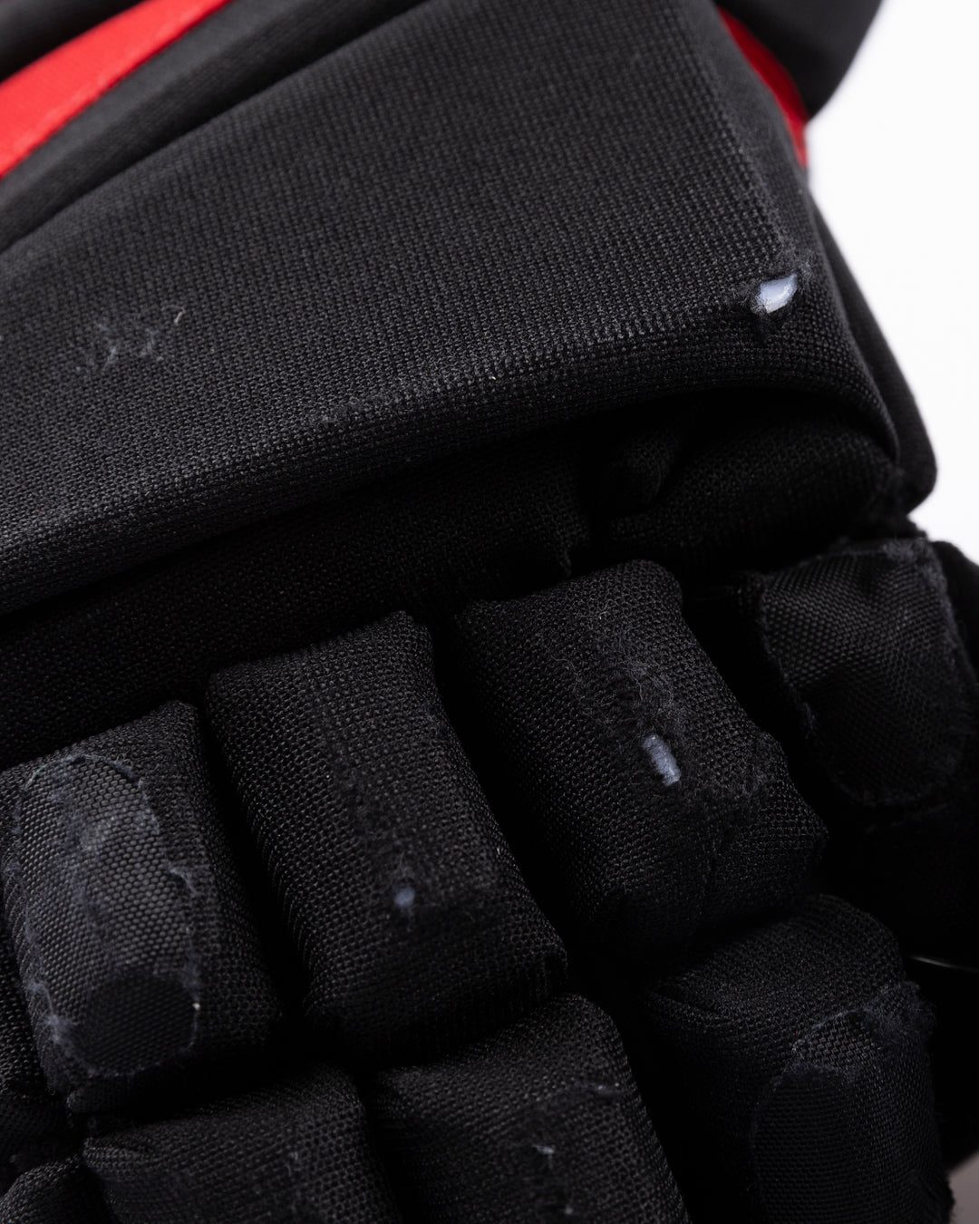 black TRUE brand hockey gloves used by Chicago Blackhawks player Tyler Bertuzzi - scuffing detail lay flat