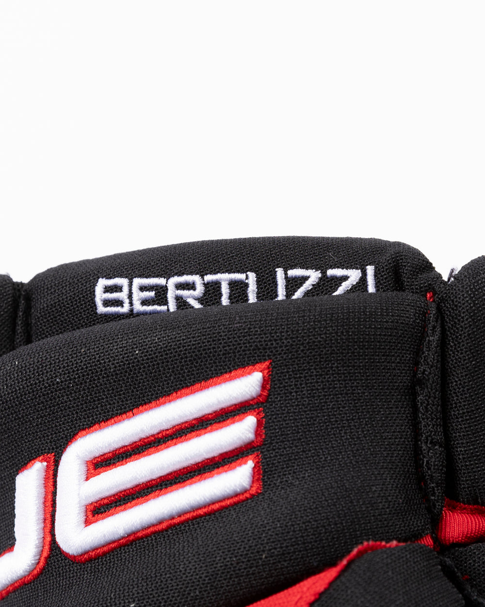 black TRUE brand hockey gloves used by Chicago Blackhawks player Tyler Bertuzzi - name detail lay flat