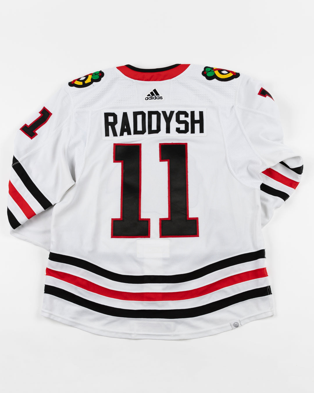 white adidas Chicago Blackhawks away jersey game used by Taylor Raddysh - back lay flat