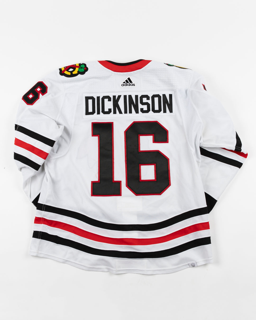 white adidas Chicago Blackhawks game used hockey jersey used by Blackhawks player Jason Dickinson - back lay flat