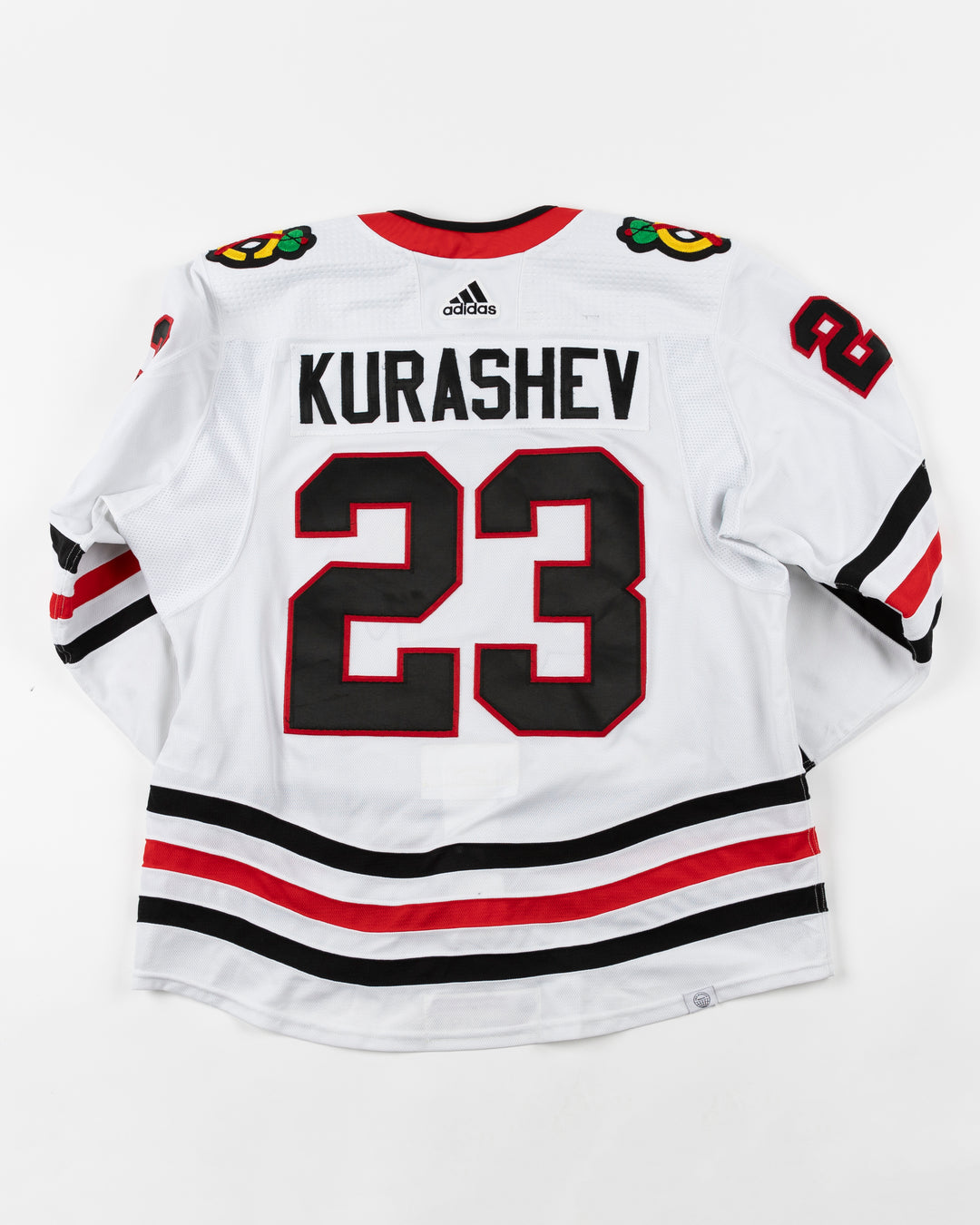 white adidas Chicago Blackhawks away jersey game used by Philipp Kurashev - back lay flat