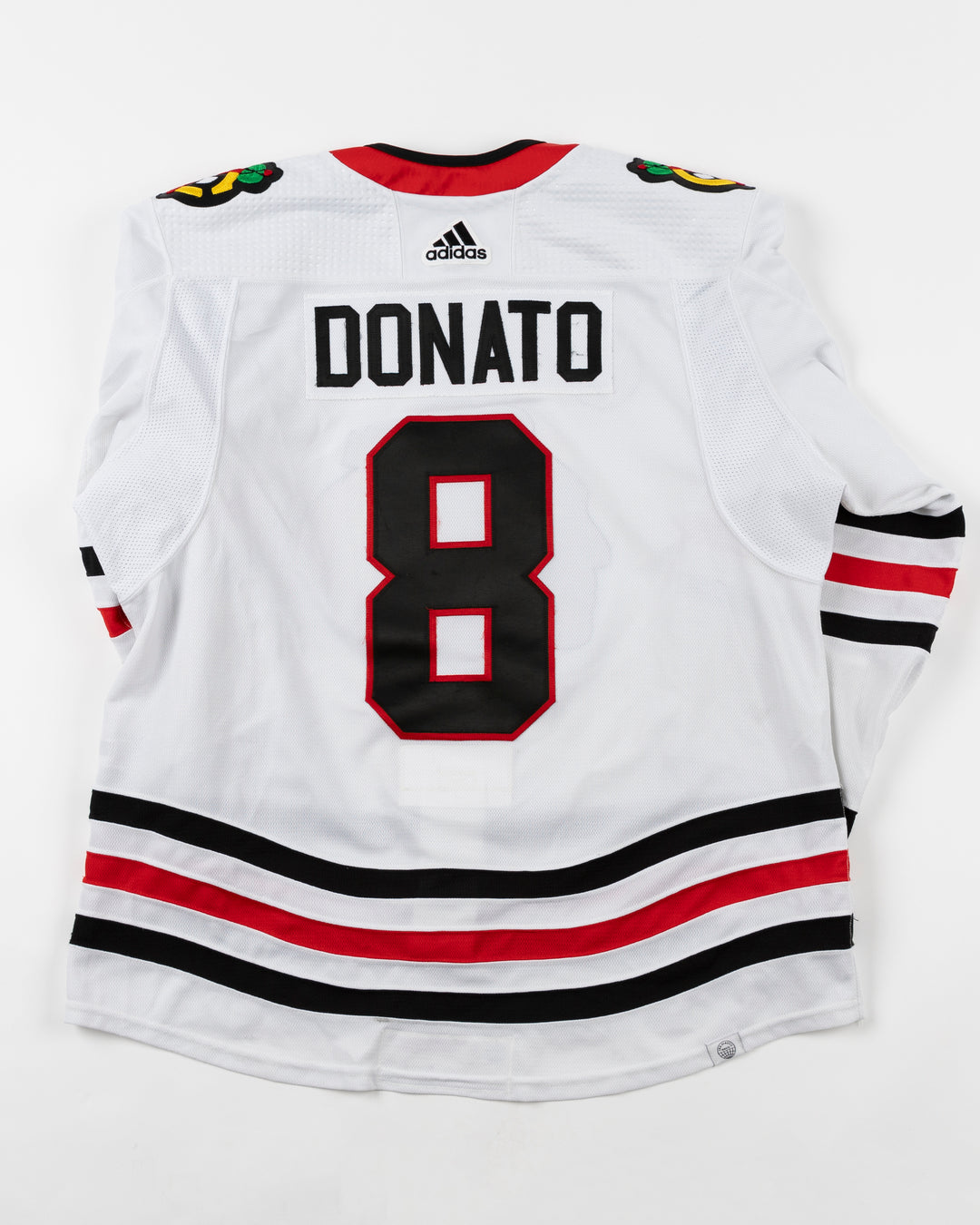 white Chicago Blackhawks adidas away jersey game used by Blackhawks player Ryan Donato - back lay flat