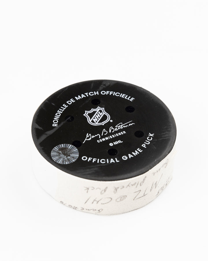 official Chicago Blackhawks game-used hockey puck used in the game against the Montreal Canadiens on January 3, 2025 - back angle lay flat