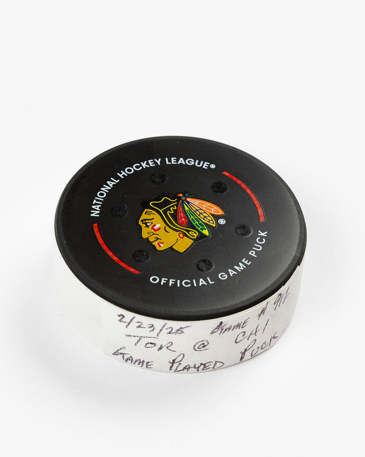 February 2025 official Chicago Blackhawks game-used hockey puck - front angle lay flat