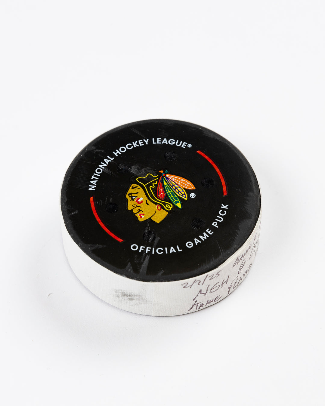 February 2025 official game-used Chicago Blackhawks hockey puck - front angle lay flat