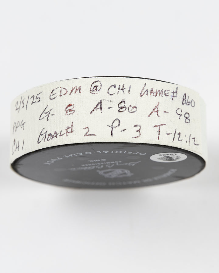 official Chicago Blackhawks game-used goal hockey puck scored by Ryan Donato against the Edmonton Oilers on February 5, 2025 - side lay flat of tape