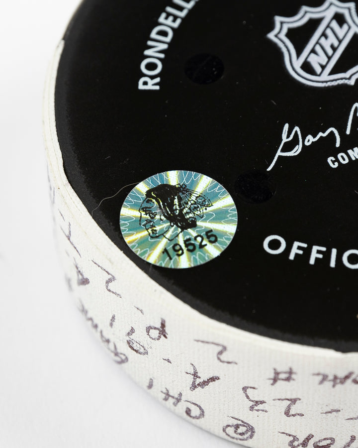 official Chicago Blackhawks game-used goal puck scored by Philipp Kurashev against the Toronto Maple Leaves on February 23, 2025 - hologram sticker detail lay flat