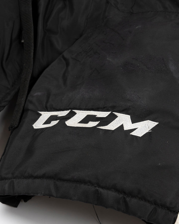 black CCM hockey pants used by Chicago Blackhawks player Wyatt Kaiser - logo detail lay flat