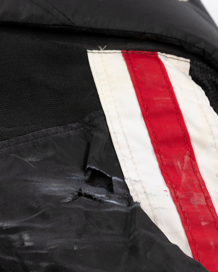 black CCM hockey pants used by Chicago Blackhawks player Wyatt Kaiser - rip detail lay flat