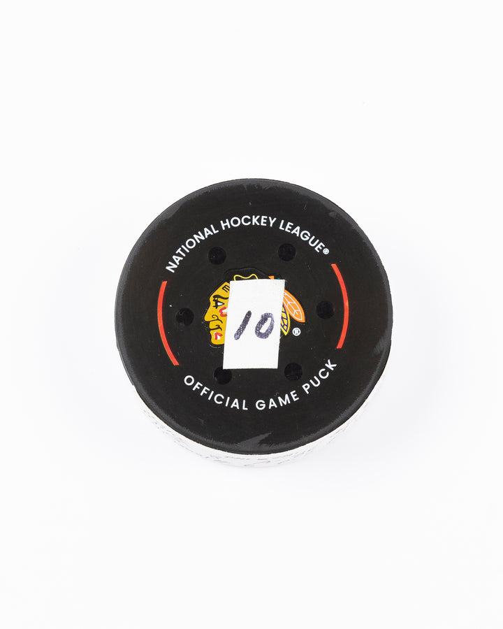 official hockey goal puck scored by Chicago Blackhawks player Ryan Donato on 3/23/25 - front lay flat