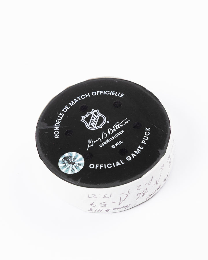official hockey goal puck scored by Chicago Blackhawks player Ryan Donato on 3/23/25 - back angle lay flat