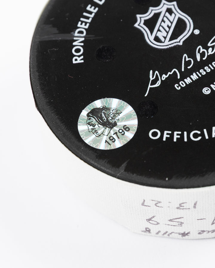 official hockey goal puck scored by Chicago Blackhawks player Ryan Donato on 3/23/25 - hologram sticker detail lay flat
